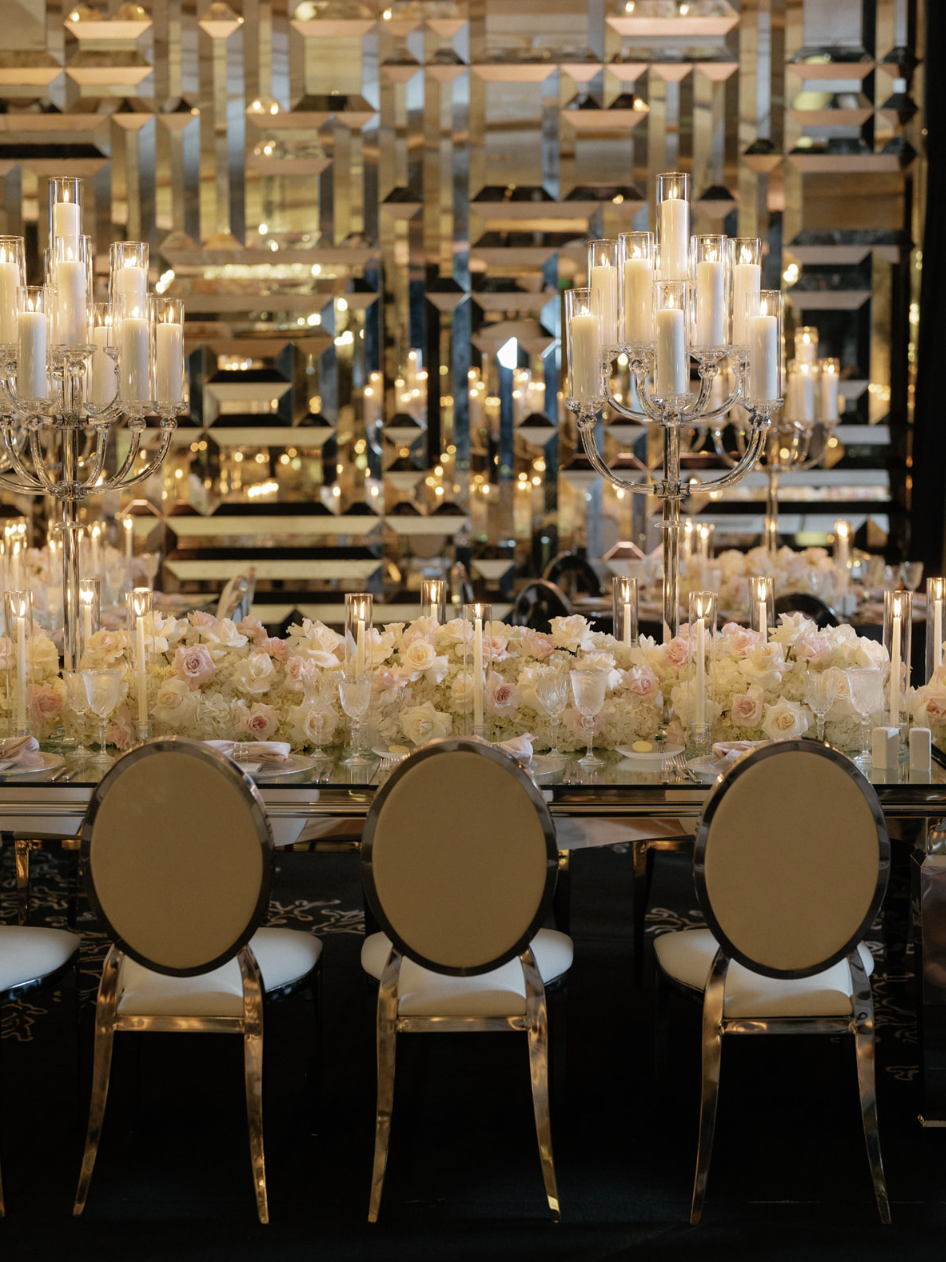 Crystal candelabras and gold mercury vessels paired with blush and ivory roses on a long table