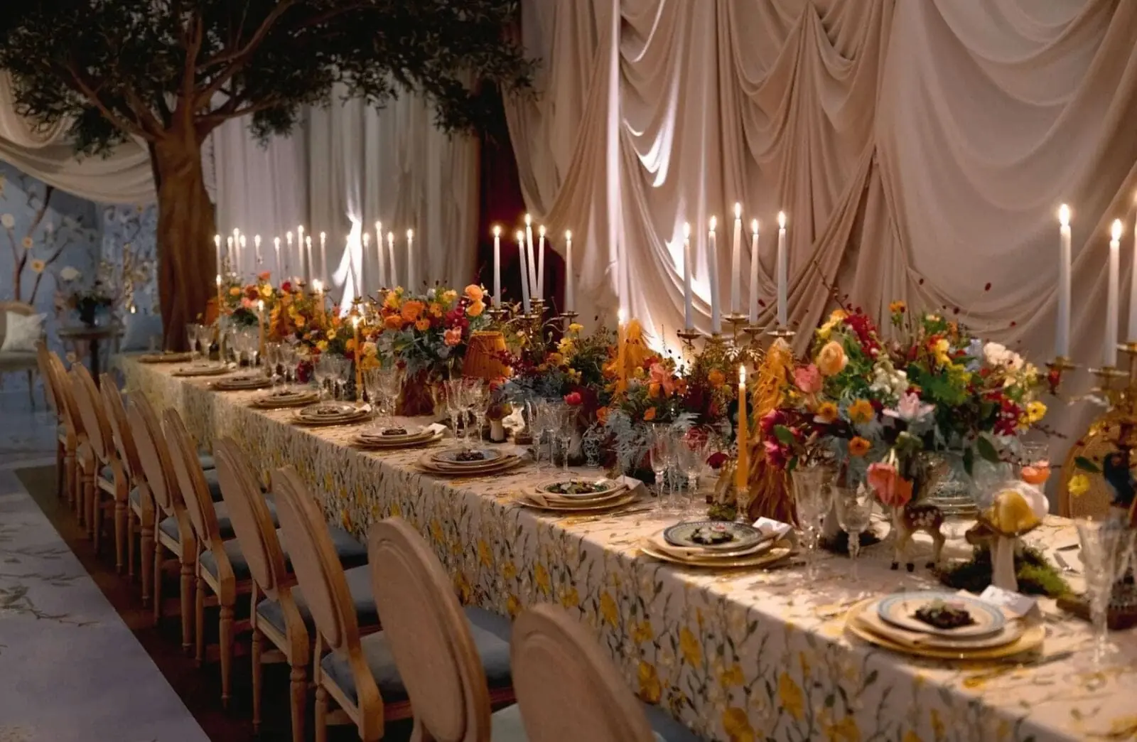Enchanted Garden Dinner - Olive trees, draped fabric, and wildflower runner with glowing taper candles by Aura Design Flowers Miami