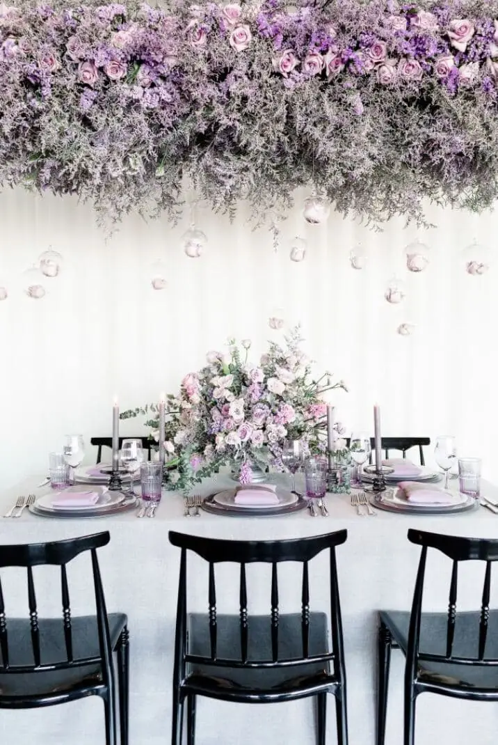 Suspended lavender rose and statice floral canopy with hanging glass baubles above editorial tablescape - lavender photoshoot