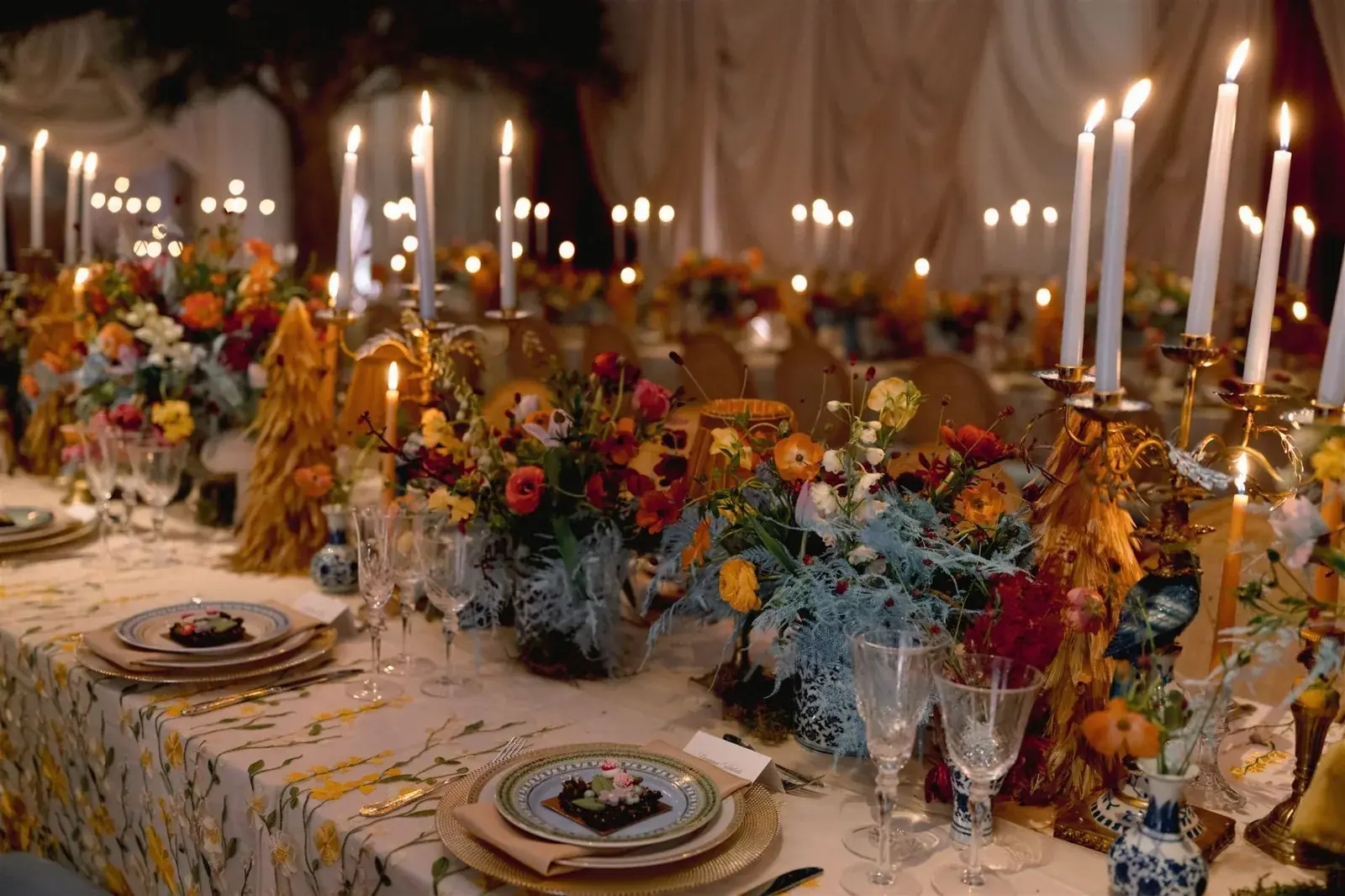 Romantic candlelit tablescape with colorful poppies and ranunculus at luxury Miami celebration