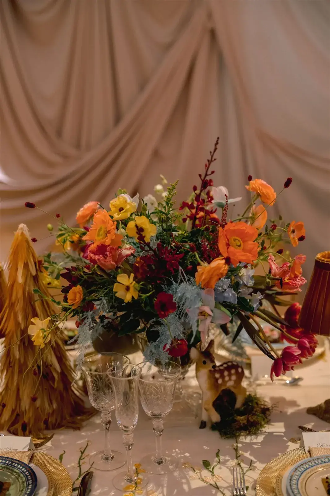 Lush wildflower centerpiece with poppies, ranunculus, and dusty miller at Miami luxury event