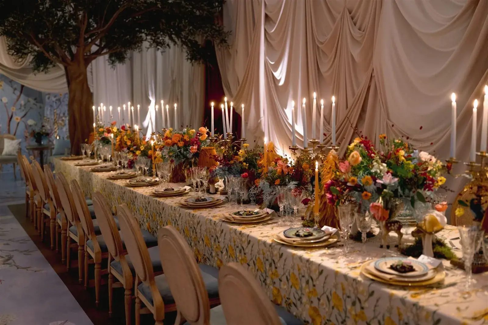 Long candlelit reception table with vibrant floral runners and taper candles at luxury Miami baby shower