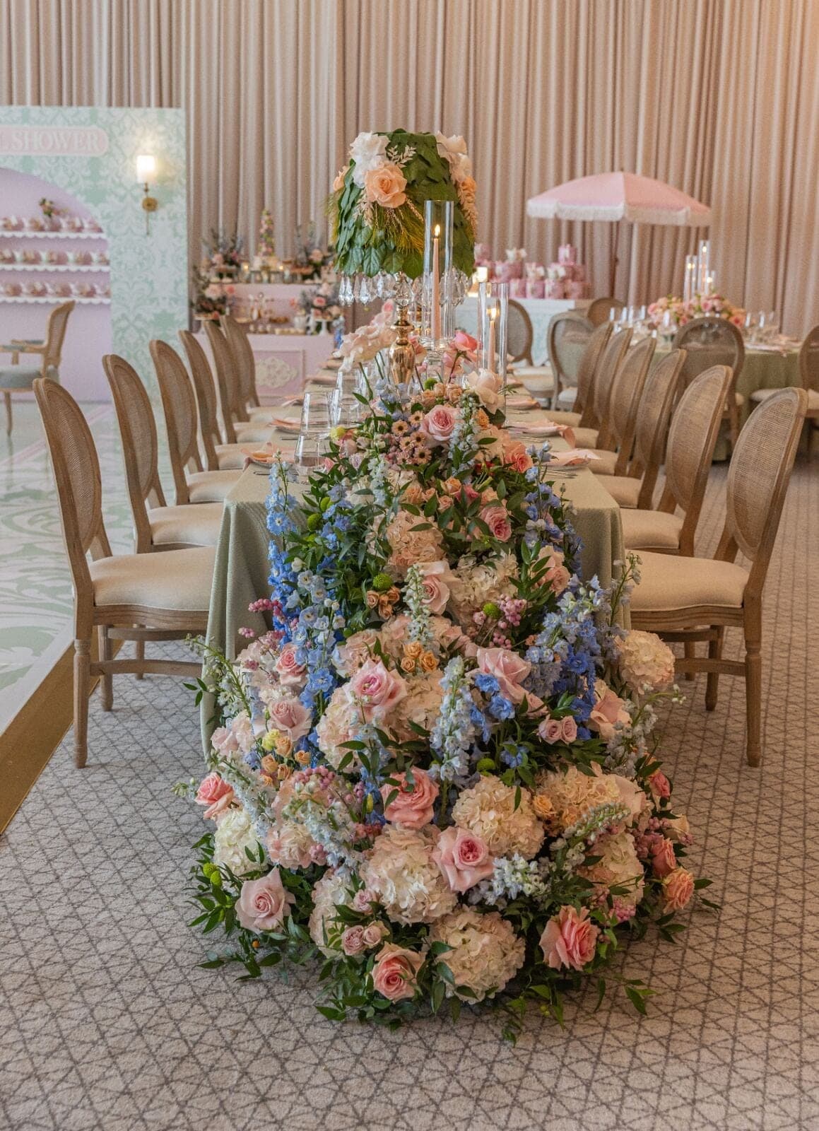Lush pastel floral runner cascading to the floor with green lampshade centerpiece at luxury Miami baby shower