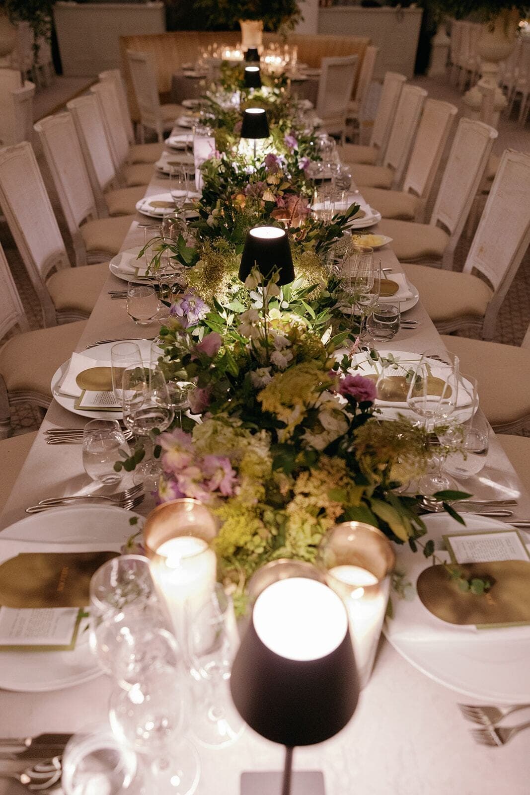 Garden Table Runner - Lush pastel floral runner glowing with candlelight along a long banquet table by Aura Design Flowers Miami