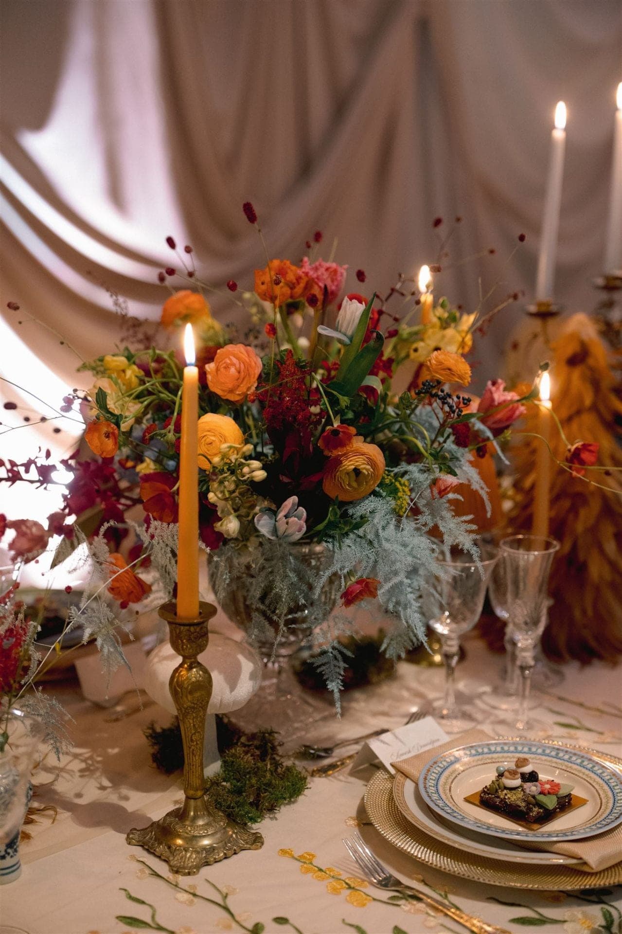Candlelit Garden Tablescape - Layered ranunculus in burnt orange, blush, and amber with heirloom brass and drifting tapers by Aura Design Flowers Miami