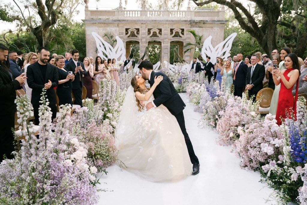 The First Kiss - Ceremony surrounded by a lush floral aisle by Aura Design Flowers Miami