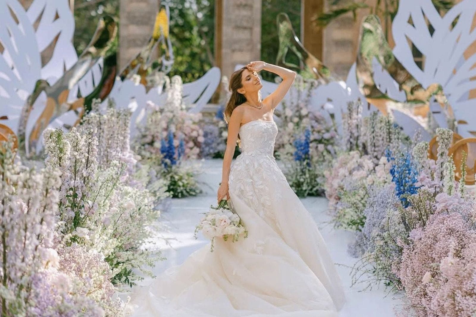 Bride surrounded by lavender and blue floral ceremony installation