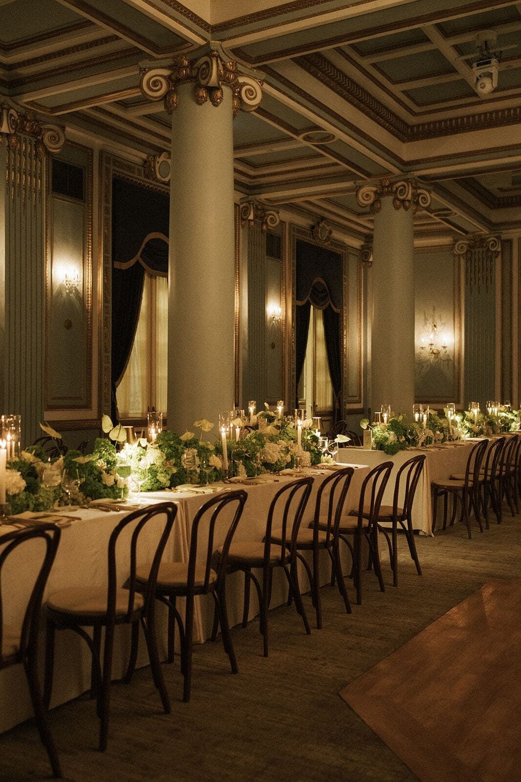 Heritage Ballroom Tablescape - Long ivory tables with greenery garlands and taper candles in a gilded ballroom by Aura Design Flowers Miami
