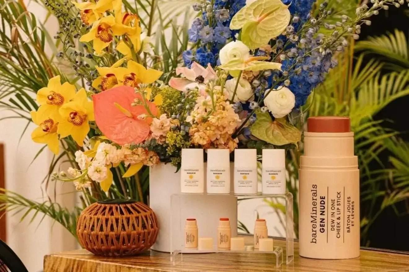 Floral brand activation at The Moore Miami by Aura Design Flowers, with cymbidium orchid and delphinium framing the product lineup